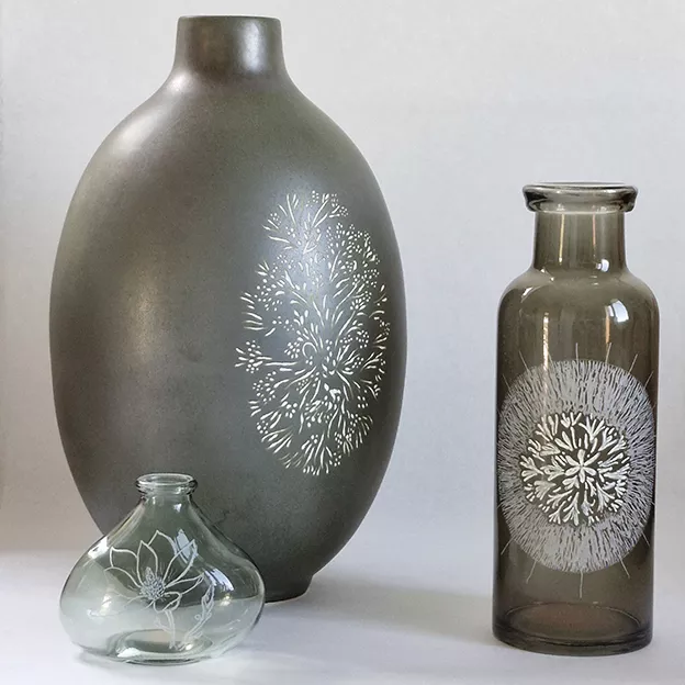 Poettery, gravure sur poterie d'un oiseau martin-pêcheur en vol entouré d'un motif végétal, par lletc