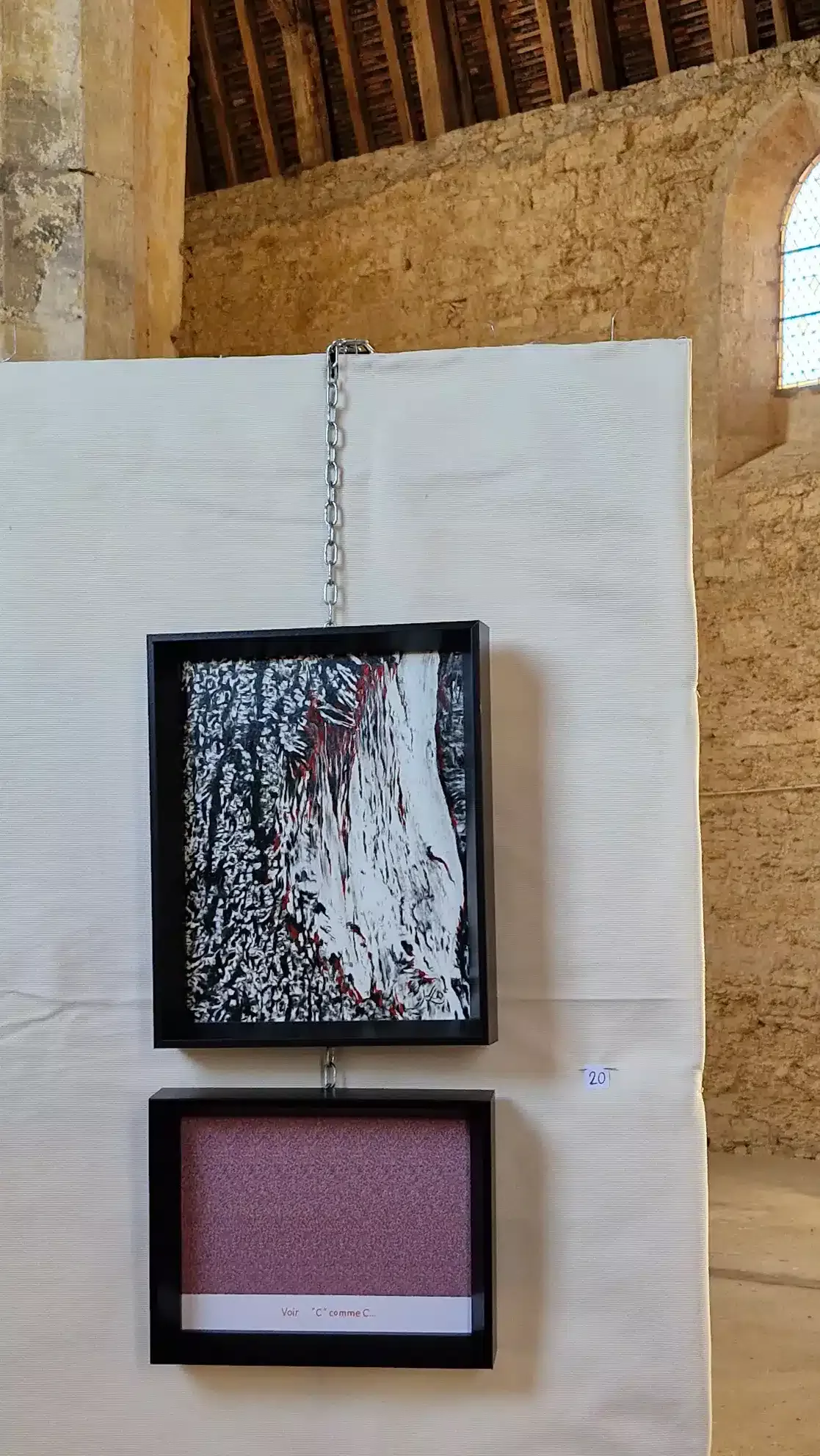 tableau noir et blanc évoquant forme mais abstrait et cartel imitant tableau en dessous avec mot titre caché